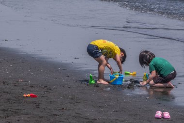 Tokyo, Japonya - 30 Nisan 2018. Enoshima Adası'nda bir plajda oynayan çocuklar