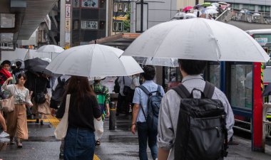 Tokyo, Japonya - 4 Temmuz 2018. Yayalar şemsiyelerle Shibuya sokakta yürüme.