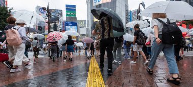 Tokyo, Japonya - 4 Temmuz 2018. Yağmurlu bir günde sırasında ünlü Shibuya kapış geçmeye bekleyen şemsiye ile yaya.