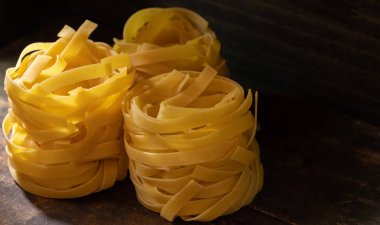 Ahşap tahta üzerinde kurutulmuş tagliatelle makarna