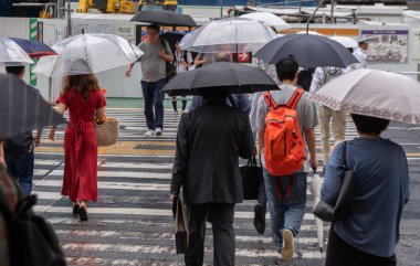 Tokyo, Japonya - 4 Temmuz 2018. Yayalar şemsiyelerle Shibuya sokakta yürüme.