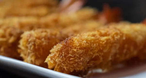 Deep fried prawns coated with crispy flour in white plate over wooden background