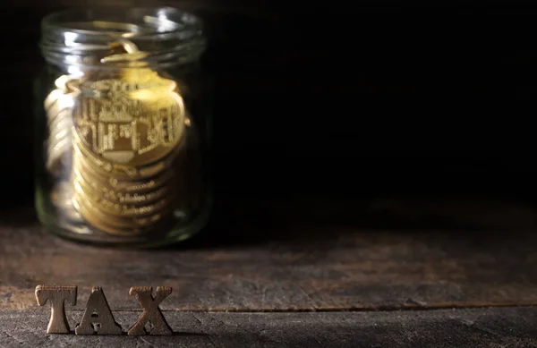 Ξύλινη Λέξη Φόρου Χρυσά Νομίσματα Στο Βάζο Κτιστών Σκούρο Φόντο — Φωτογραφία Αρχείου