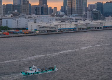 Ship floating in sea on city background