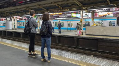 TOKYO, JAPAN - JULY 16TH, 2018. Commuters  in Japan Railway train during the morning rush hour in Shinjuku Station. clipart