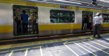 Tokyo, Japonya - 16 Temmuz 2018. Japonya demiryolu Shinjuku commuters platformu sabah saatinde istasyonu. Seçici odak.