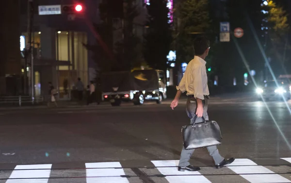 2018 東京都 夜に浅草で横断歩道を横切ってのオフィスの装いでブリーフケースを持つ男 — ストック写真