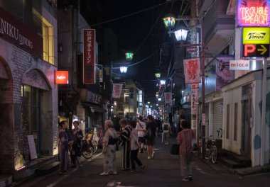 Tokyo, Japonya - 12 Ağustos 2018. Backstreet Shimokitazawa mahalle geceleri sokak yürüyüş insanlar.