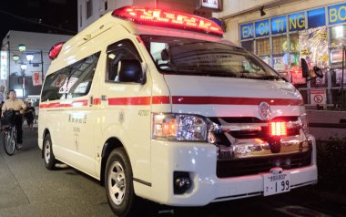 TOKYO, JAPAN - AUGUST 12TH, 2018. Ambulance emergency services in the street of Shimokitazawa at night. clipart