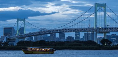 Tokyo, Japonya - 15 Ağustos 2018. Akşam yemeği cruise gemi, veya yerel olarak Gökkuşağı Köprüsü ile ndusk içinde belgili tanımlık geçmiş vasıl Sumida nehir boyunca yelken yakatabune olarak bilinen.
