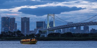 Tokyo, Japonya - 15 Ağustos 2018. Akşam yemeği cruise gemi, veya yerel olarak Gökkuşağı Köprüsü ile ndusk içinde belgili tanımlık geçmiş vasıl Sumida nehir boyunca yelken yakatabune olarak bilinen.
