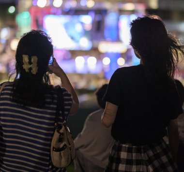 Tokyo, Japonya - 15 Ağustos 2018. Genç Japon kız ile gece Odaiba içinde smartphone.