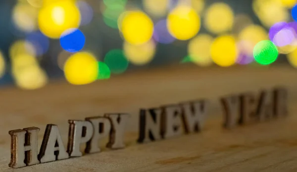 Happy New Year Деревянные Буквы Огнями Боке Фоне Селективный Фокус — стоковое фото