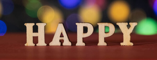 HAPPY деревянное слово с огнями bokeh backgropund
