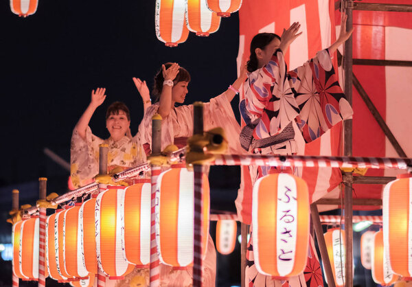 TOKYO, JAPAN - AUGUST 12TH, 2018. Dancers in traditional yukata dancing on the stage at the Bon Odori celebration in Shimokitazawa neighborhood at night.