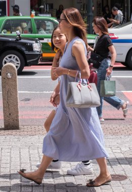 Tokyo, Japonya - 19 Ağustos 2018. Japon kız Shibuya sokakta yürürken.