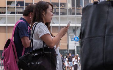 Tokyo, Japonya - 19 Ağustos 2018. Shibuya içinde karşıdan karşıya bekleyen smartphone ile Japon kız.