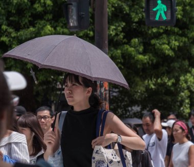 Tokyo, Japonya - 19 Ağustos 2018. Sıcak bir yaz günü Shibuya içinde sırasında şemsiye ile Japon kadın.