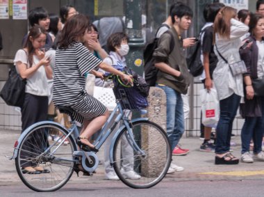 Tokyo, Japonya - 19 Ağustos 2018. Genç Japon kız Shibuya sokakta bir bisiklet sürme
