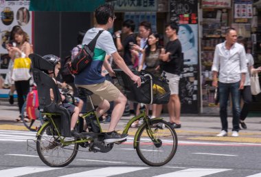 Tokyo, Japonya - 19 Ağustos 2018. Japon baba çocuğunu Shibuya sokakta bir bisiklet sürme.