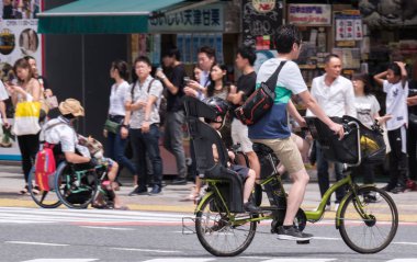 Tokyo, Japonya - 19 Ağustos 2018. Japon baba çocuğunu Shibuya sokakta bir bisiklet sürme.