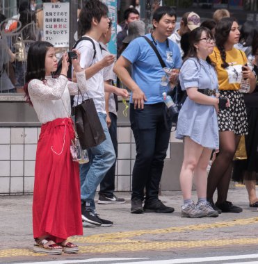 Tokyo, Japonya - 19 Ağustos 2018. Shibuya içinde karşıdan karşıya bekleyen smartphone ile Japon kız.