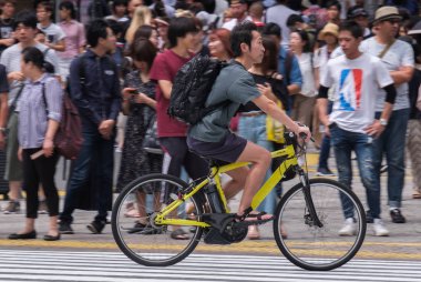 Tokyo, Japonya - 19 Ağustos 2018. Adam sokakta Shibuya bir bisiklet sürme