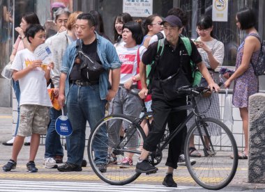 Tokyo, Japonya - 19 Ağustos 2018. Uber yiyor binici Shibuya Caddesi Bisiklete binme.