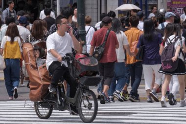 Tokyo, Japonya - 19 Ağustos 2018. Japon baba çocuğunu sokakta Shibuya ile yeni bisiklet sürme.