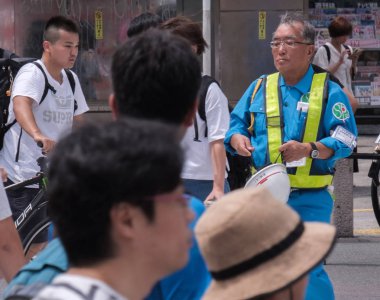 Tokyo, Japonya - 19 Ağustos 2018. Shibuya içinde karşıdan karşıya genel bir bekleyen yaşlı inşaat işçisi.