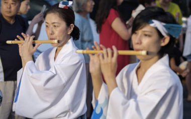 Tokyo, Japonya - 19 Ağustos 2018. Geleneksel shinobue flüt eşlik eden dans topluluğu Shimokitazawa Awa Odori Festivali sırasında sokakta oynayan kadın müzisyen.