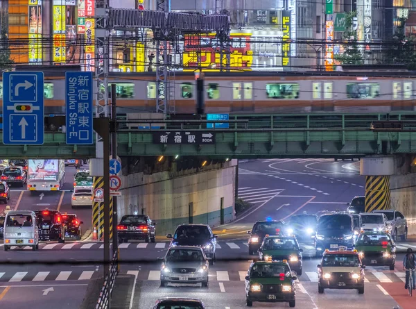 2018 東京都 新宿歌舞伎町地区における道路橋の上を通過する通勤電車 — ストック写真