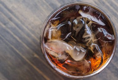 Bir bardak kola içkiler ahşap masa üstü buz ile