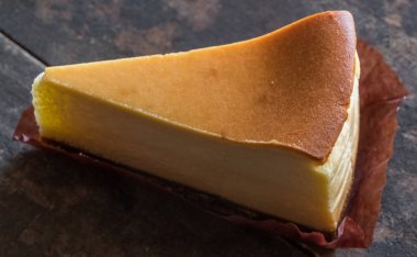 Ahşap masa üstüne peynir pasta bir dilim