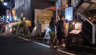 Tokyo, Japonya - 12 Ağustos 2018. Backstreet Shimokitazawa mahalle geceleri sokak yürüyüş insanlar.