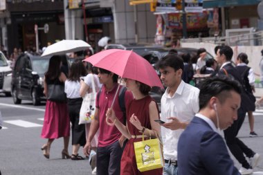 Tokyo, Japonya - 19 Ağustos 2018. Kırmızı şemsiye ve elbise sıcak bir yaz günü Shibuya içinde sırasında Japon kadınla.