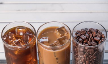 Ahşap arka plan üzerinde siyah kahve, soğuk latte ve fasulye buzlu