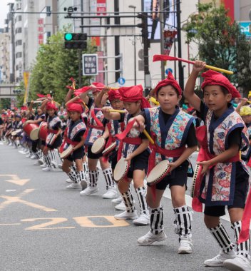 Tokyo, Japonya - 29 Temmuz 2018. Okul çocukları renkli geleneksel üniformalı Shinjuku EISA Festivali'nde onların alışılmış çalışma yöntemi gerçekleştirme.