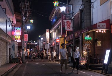 Tokyo, Japonya - 12 Ağustos 2018. Backstreet Shimokitazawa mahalle geceleri sokak yürüyüş insanlar.