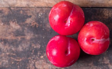 Koyu ahşap arka plan üzerinde kırmızı erik