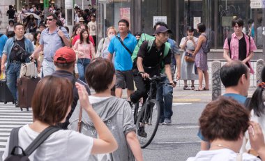 Tokyo, Japonya - 19 Ağustos 2018. Uber yiyor binici Shibuya Caddesi Bisiklete binme.