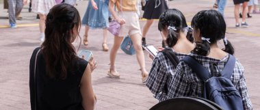 Tokyo, Japonya - 19 Ağustos 2018. Japon kızlar Shibuya sokakta smartphone ile aynı elbise.