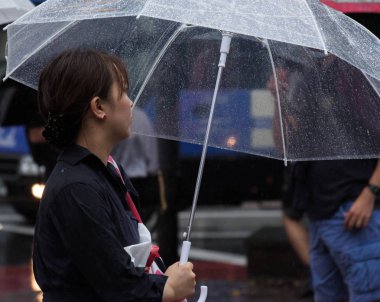 Tokyo, Japonya - 29 Temmuz 2018. Shibuya içinde yağmurlu tayfun sezonunda şemsiye ile Japon kız.