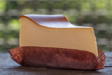 Ahşap masa üstüne peynir pasta bir dilim