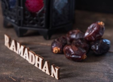 Ahşap arka plan üzerinde Ramadhan metin ve fener ile Tarihler meyve