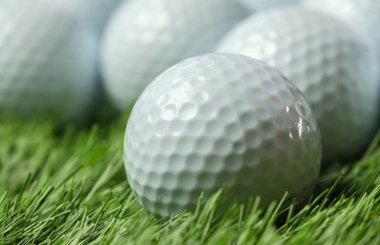 Yeşil çimenlerin üzerinde golf topları