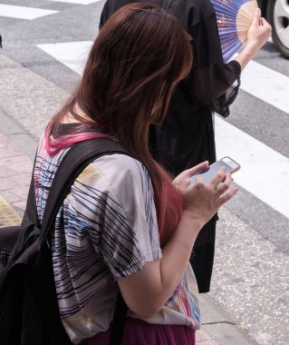 Tokyo, Japonya - 19 Ağustos 2018. Japon kız ile smartphone Shibuya sokakta.
