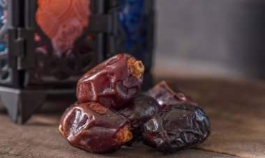 Ahşap masada mum fener ile Tarihler meyve