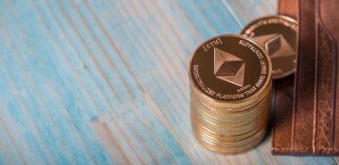 Ahşap masa üzerinde deri cüzdan ile Ethereum sikkeler