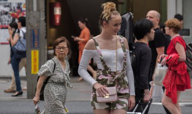 Tokyo, Japonya - 29 Temmuz 2018. Kadın turist Shinjuku Caddesi'nde poz.